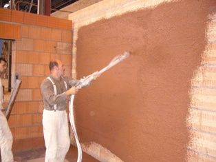 Pressefoto: , 2008 © Mit der Putzmaschine kriegt man den Lehmputz sauber und schnell an die Wand