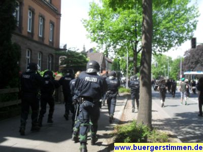 Pressefoto: http://www.buergerstimmen.de/ , 2011 © Fir Polizisten laufen zwecks Absperrung des bahnhofszugangs zur Kreuzung Bahnhofstraße-Güterbahnhofstraße